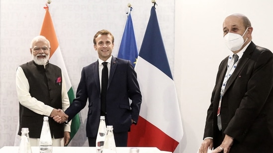 Indian Prime Minister Narendra Modi shakes hands with French President Emmanuel Macron next to France's European and Foreign Affairs Minister Jean-Yves Le Drian during a bilateral meeting at the G20 leaders' summit in Rome.(AFP)