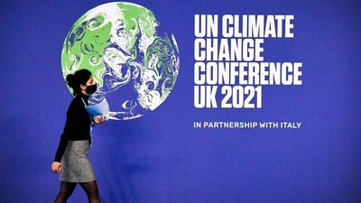 A participant walks past a COP26 UN Climate Change Conference' poster on the first day of the COP26 UN Climate Change Conference at the Scottish Event Campus in Glasgow, Scotland, on Sunday. (AFP) A participant walks past a COP26 UN Climate Change Conference' poster on the first day of the COP26 UN Climate Change Conference at the Scottish Event Campus in Glasgow, Scotland, on Sunday. (AFP)