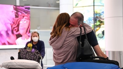 An international traveller is embraced at Sydney Airport in the wake of coronavirus disease border restrictions easing,&nbsp; (REUTERS)