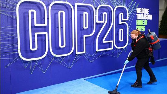 An employee is seen working before the arrival of leaders for the COP26 UN climate change summit in Glasgow on November 1, 2021. (AFP)