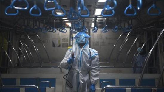 A file photo of a railway worker spraying disinfectant in a local train coach in Kolkata, Bengal. (HT/ File photo)