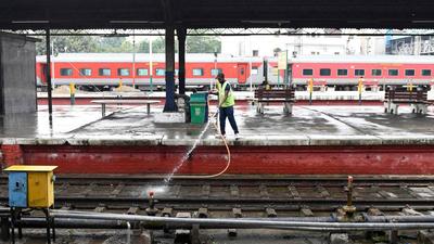 An Indian Railways employee washes tracks at a station in Amritsar. Indian Railways has made it easier now to get permits for filming on its premises. (AFP)