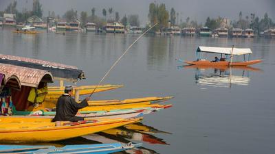 A boatman on a shikara at Dal Lake in Srinagar on Sunday. The Jammu and Kashmir (J&K) home department on Monday gave the go-ahead for the formation of the State Investigation Agency (SIA). (PTI)