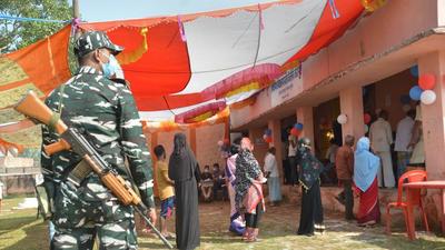 A security personnel stands vigil at a polling station as voters stand in a queue to cast their votes during the bye-election of the Tarapur assembly constituency, in Munger district, on Saturday. (PTI) A security personnel stands vigil at a polling station as voters stand in a queue to cast their votes during the bye-election of the Tarapur assembly constituency, in Munger district, on Saturday. (PTI)