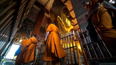 Buddhist monks are seen next to the Reclining Buddha at Wat Pho, a day after country's reopening campaign which is a part of the government's plan to jump start the pandemic-hit tourism sector in Bangkok, Thailand. (REUTERS)