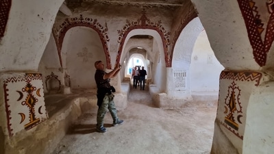 European tourists, escorted by security personnel, visit the old town of Ghadames, a desert oasis some 650 kilometres (400 miles) southwest of the Libyan capital Tripoli, during an organised tour in the town. (Photo by Mahmud TURKIA / AFP) European tourists, escorted by security personnel, visit the old town of Ghadames, a desert oasis some 650 kilometres (400 miles) southwest of the Libyan capital Tripoli, during an organised tour in the town. (Photo by Mahmud TURKIA / AFP)