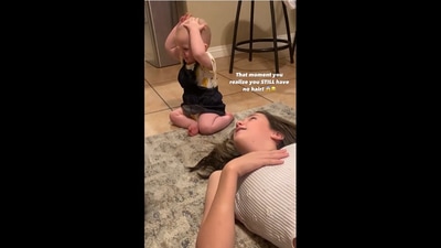 The baby realises that she has no hair on her own head after touching her mom's hair. (instagram/@ktgirlie01) The baby realises that she has no hair on her own head after touching her mom's hair. (instagram/@ktgirlie01)