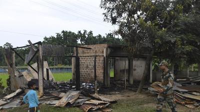 A paramilitary soldier patrols past a shop that was set on fire in Rowa village, about 220 kilometers from Agartala, in Tripura on October 26. (AP) A paramilitary soldier patrols past a shop that was set on fire in Rowa village, about 220 kilometers from Agartala, in Tripura on October 26. (AP)