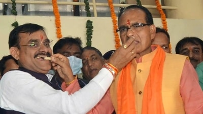 Madhya Pradesh CM Shivraj Singh Chouhan and BJP State President VD Sharma offer sweets to each other as the party leads in State assembly by-elections, at BJP State Headquarters, in Bhopal on Tuesday. (ANI Photo) (Rajeev Gupta) Madhya Pradesh CM Shivraj Singh Chouhan and BJP State President VD Sharma offer sweets to each other as the party leads in State assembly by-elections, at BJP State Headquarters, in Bhopal on Tuesday. (ANI Photo) (Rajeev Gupta)