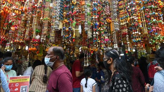 People queue outside a shop to buy goods and decorative ornaments on the eve of Diwali. (AFP Photo)