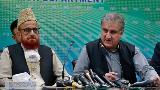 Pakistan's Foreign Minister Shah Mahmood Qureshi, right, and top religious leader Mufti Muneebur Rehman, who helped negotiate an end to a protest mach by Islamists, give a press conference, in Islamabad, Pakistan.(AP)