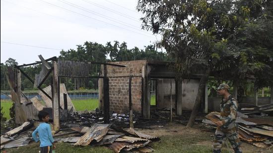 A paramilitary soldier patrols past a shop that was set on fire in Rowa village, about 220 kilometers from Agartala, in Tripura on October 26. (AP)