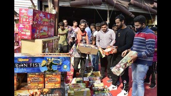 People purchasing crackers on the eve of Diwali from the market near Grain Market on Jalandhar Bypass in Ludhiana on Wednesday. (Harsimar Pal Singh/HT)