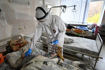 Medical personnel provides medical assistance to a Covid-19 patient inside the intensive care unit in an hospital which treats patients with COVID-19 coronavirus in Kiev (AFP)