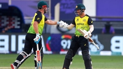 Australia's captain Aaron Finch, left, gestures to teammate David Warner during the Cricket Twenty20 World Cup match between Australia and Bangladesh in Dubai, UAE, Thursday, Nov. 4, 2021.&nbsp; (AP)