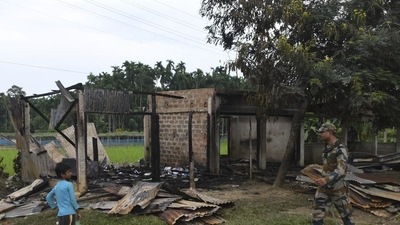 A paramilitary soldier patrols past a shop that was set on fire in Rowa village, about 220 kilometers from Agartala (AP)