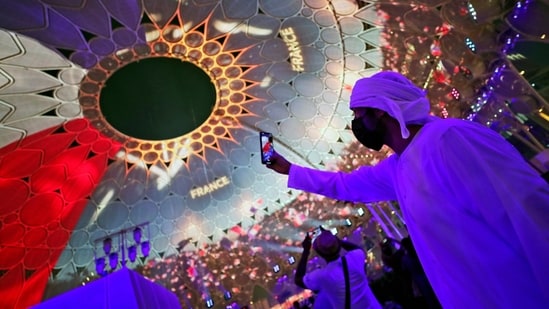 A man takes selfie under the dome of Al Wasl Plaza coloured in French national flag, during a French ceremonial day at the Dubai Expo 2020 in Dubai, United Arab Emirates(AP)