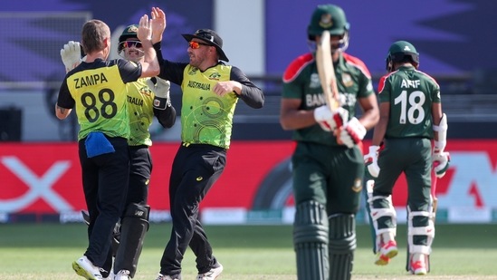 Australia's Adam Zampa, left, is congratulated by teammates after dismissing Bangladesh's Afif Hossain, right, during the Cricket Twenty20 World Cup match between Australia and Bangladesh in Dubai, UAE, Thursday, Nov. 4, 2021. (AP)