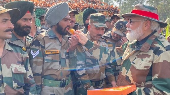 PM Narendra Modi treats soldiers with sweets on the occasion of Diwali at Nowshera in Jammu and Kashmir.(ANI )