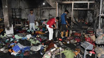Factory owners and workers rummaging through the items that perished in the fire which broke out at Shivpuri in Ludhiana on Thursday. (Harsimar Pal Singh/Hindustan Times)