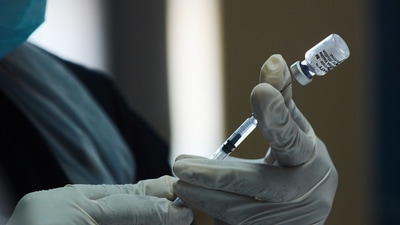 A health worker prepares a dose of the Pfizer-BioNTech Covid-19 vaccine. (Waldo Swiegers / BLOOMBERG)