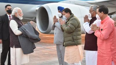 PM Narendra Modi is welcomed by CM Pushkar Singh Dhami, Governor Lt Gen Gurmit Singh (retired) and other state dignitaries at Dehradun airport in Uttarakhand on Friday morning. (HT photo)