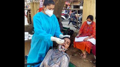 A healthcare worker collects a swab sample from a woman for Covid testing at Shalamar market in Jammu. (Shanky Rathore) A healthcare worker collects a swab sample from a woman for Covid testing at Shalamar market in Jammu. (Shanky Rathore)
