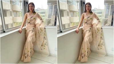 The off-white organza saree Kajal chose for Diwali festivities comes adorned with greyish and green floral patterns and gold sequinned embroidery all over the drape. She teamed the six yards with an off-white sleeveless blouse featuring a U neckline. (Instagram/@sayali_vidya) The off-white organza saree Kajal chose for Diwali festivities comes adorned with greyish and green floral patterns and gold sequinned embroidery all over the drape. She teamed the six yards with an off-white sleeveless blouse featuring a U neckline. (Instagram/@sayali_vidya)