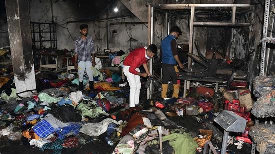 Factory owners and workers rummaging through the items that perished in the fire which broke out at Shivpuri in Ludhiana on Thursday. (Harsimar Pal Singh/Hindustan Times)