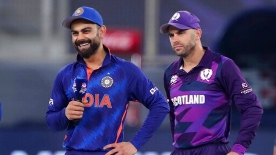 India's captain Virat Kohli, left, smiles as Scotland's captain Kyle Coetzer, right, looks on during an interaction with the commentator after Kohli won the toss ahead of the Cricket Twenty20 World Cup match between India and Scotland in Dubai, UAE, Friday, Nov. 5, 2021. (AP Photo/Aijaz Rahi)(AP)