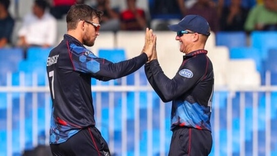 iNamibia's captain Gerhard Erasmus, left, celebrates with teammate Craig Williams, right, after taking the wicket of New Zealand's captain Kane Williamson during the Cricket Twenty20 World Cup match between New Zealand and Namibia, in Sharjah, UAE, Friday, Nov. 5, 2021. (AP Photo/Kamran Jebreili)(AP)