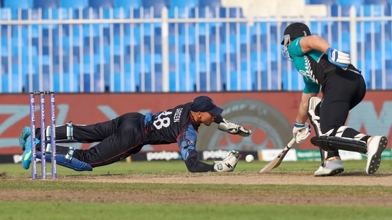 Namibia's Zane Green dives to field the ball as New Zealand's Jimmy Neesham reaches out to make his ground during the Cricket Twenty20 World Cup match between New Zealand and Namibia, in Sharjah, UAE, Friday, Nov. 5, 2021. (AP Photo/Kamran Jebreili)(AP)