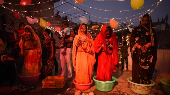 Women perform rituals during Chhath Puja celebrations at Baba Farid Puri in New Delhi.(Sanchit Khanna/ Hindustan Times/File)