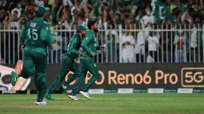Pakistan's Mohammad Hafeez, right, celebrates the dismissal of New Zealand's Jimmy Neesham during the Cricket Twenty20 World Cup match between New Zealand and Pakistan in Sharjah, UAE, Tuesday, Oct. 26, 2021. (AP)