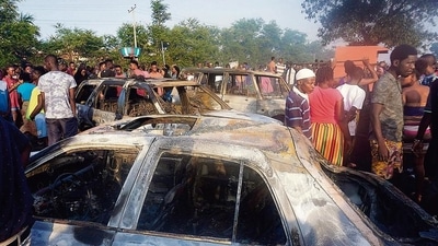 People look on at burnt cars in the aftermath of a fuel tanker explosion in Freetown. (AFP) People look on at burnt cars in the aftermath of a fuel tanker explosion in Freetown. (AFP)