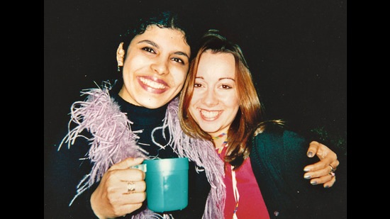 Being a teetotaller with a cup of juice, with her friend Laura at a house party Being a teetotaller with a cup of juice, with her friend Laura at a house party