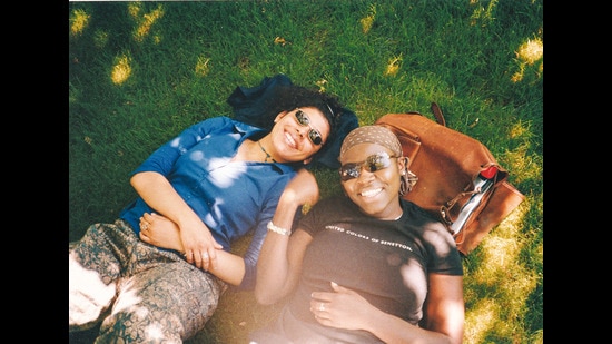 With her friend Shirine (right), lounging on the grass on campus With her friend Shirine (right), lounging on the grass on campus
