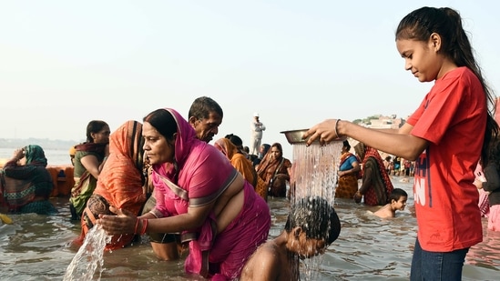 Women perform rituals for their brothers' long lives in the Yamuna river on the occasion of Bhai Dooj, in Prayagraj.(ANI)