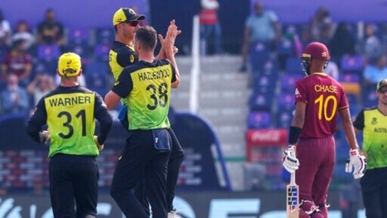 Australia's Josh Hazlewood is congratulated by teammates after dismissing West Indies' Roston Chase, right, during the Cricket Twenty20 World Cup match between Australia and the West Indies in Abu Dhabi, UAE, Saturday, Nov. 6, 2021. (AP Photo/Kamran Jebreili)(AP)