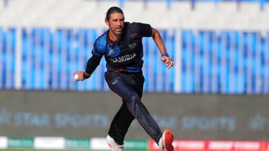 Namibia's David Wiese throws the ball to run out Ireland's Mark Adair during the Cricket Twenty20 World Cup first round match between Namibia and Ireland in Sharjah, UAE, Friday, Oct. 22, 2021.(AP)