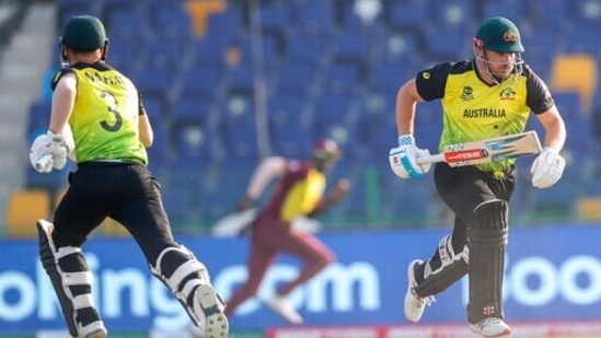 Australia's captain Aaron Finch, right, and teammate David Warner cross as they run between the wickets during the Cricket Twenty20 World Cup match between Australia and the West Indies in Abu Dhabi, UAE, Saturday, Nov. 6, 2021. (AP Photo/Kamran Jebreili)(AP)
