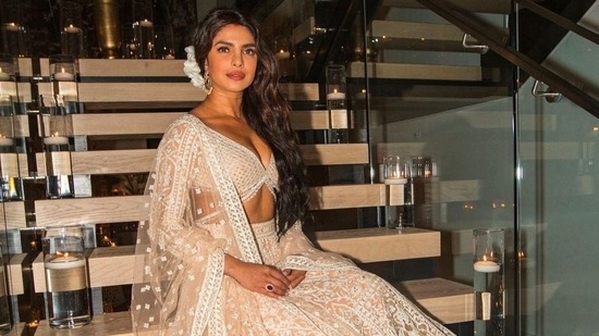 Priyanka Chopra poses in a lehenga on the staircase. Her Los Angeles home is washed in white.&nbsp;