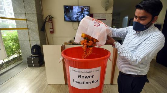 A man deposits leftover flowers from Diwali celebration in Noida on Friday. (Sunil Ghosh/HT photo)