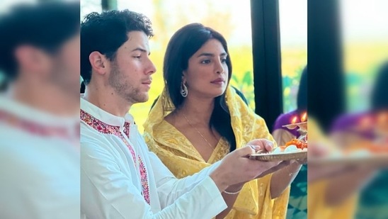 Priyanka Chopra donned a beautiful yellow printed saree while Nick Jonas looked dapper in his white kurta pyjama with red neck borders.(Instagram/@priyankachopra)
