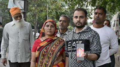 The girl’s father showing her picture after she was abducted from the mother and child ward of Ludhiana civil hospital on Saturday. (HT File)