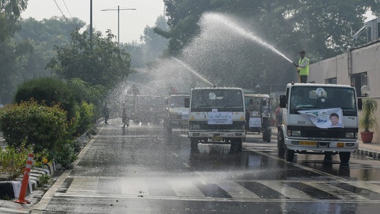 Public Works Department (PWD) workers spray water to curb the air pollution in New Delhi on Saturday. (ANI Photo) Public Works Department (PWD) workers spray water to curb the air pollution in New Delhi on Saturday. (ANI Photo)