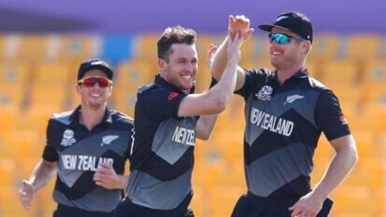 New Zealand's Adam Milne, second left, is congratulated by teammate Jimmy Neesham after taking the wicket of Afghanistan's Mohammad Shahzad during the Cricket Twenty20 World Cup match between New Zealand and Afghanistan in Abu Dhabi, UAE, Sunday, Nov. 7, 2021. (AP Photo/Kamran Jebreili)(AP)