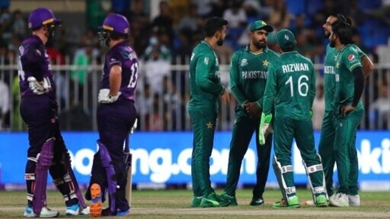 Pakistan's captain Babar Azam, fourth right, talks to his teammates as they await third umpire's decision for a Scotland batsman during the Cricket Twenty20 World Cup match between Pakistan and Scotland in Sharjah, UAE, Sunday, Nov. 7, 2021.(AP)