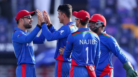 Afghanistan's Mujeeb Ur Rahman, centre, is congratulated by teammates after taking the wicket of New Zealand's Daryl Mitchell during the Cricket Twenty20 World Cup match between New Zealand and Afghanistan in Abu Dhabi, UAE, Sunday, Nov. 7, 2021. (AP Photo/Kamran Jebreili)(AP)
