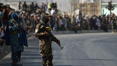 People watch a Taliban military parade of the Al-Badr unit in Kandahar on November 8, 2021. (AFP) People watch a Taliban military parade of the Al-Badr unit in Kandahar on November 8, 2021. (AFP)